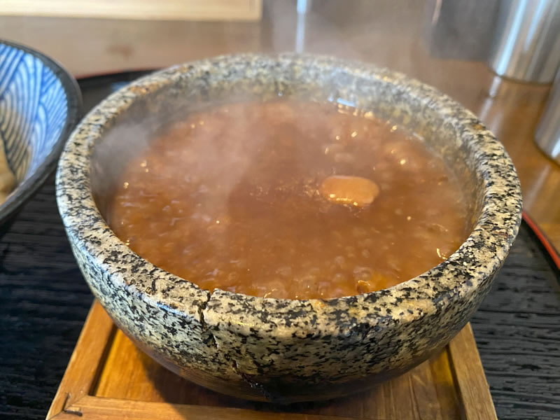 麺の道あをによしのつけ汁が石焼窯でぐつぐつ煮えている画像