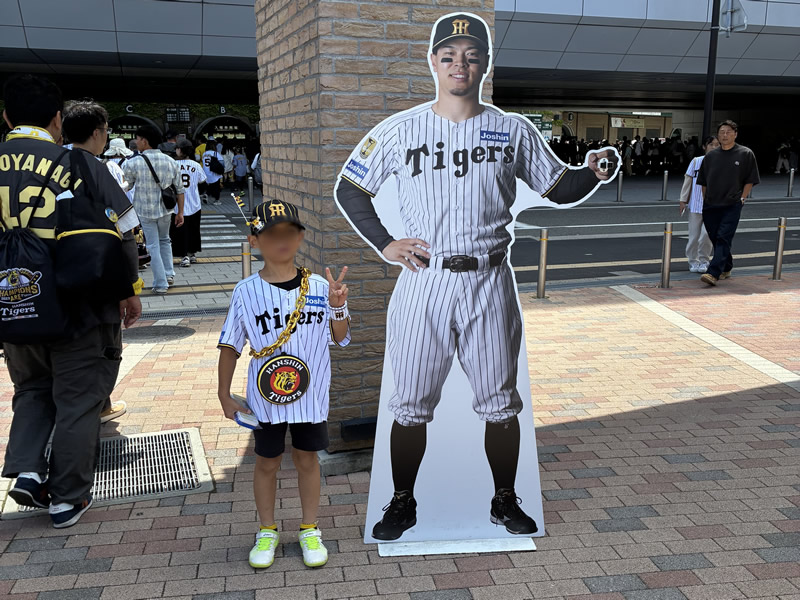 佐藤輝明選手大好き少年。チャンピオンエンブレム付きユニフォーム、帽子、ネックレス、リスト、応援バット、タオル、…“全身フル装備”